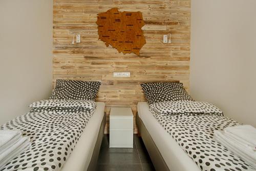 two beds sitting next to each other in a room at Apartamenty Centrum M - Komfortowe Noclegi in Piaseczno