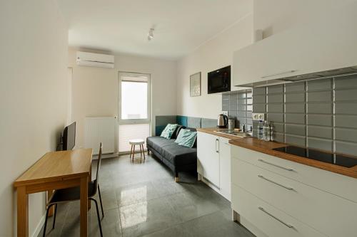 a kitchen and living room with a couch and a table at Apartamenty Centrum M - Komfortowe Noclegi in Piaseczno