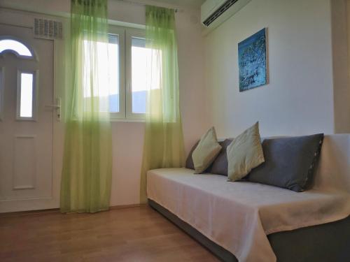 a couch sitting in a room with a window at Apartment Mare in Crikvenica