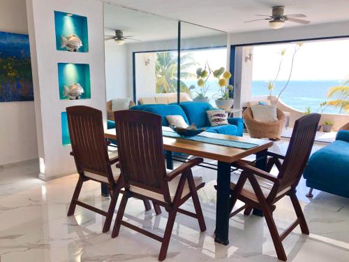 a dining room with a blue couch and a table and chairs at Flamingo Paradise Front by Cielo Maya in Cancún