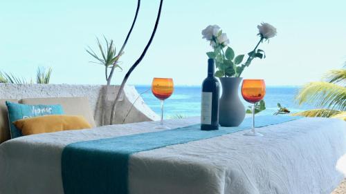 ein Tisch mit zwei Gläsern und einer Flasche Wein in der Unterkunft Flamingo Paradise Front by Cielo Maya in Cancún