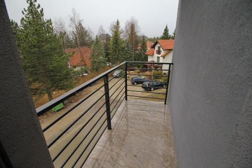 uma varanda de uma casa com um carro na chuva em Binis em Zlatibor