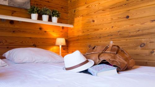 a bedroom with a bed with a hat and books at Chaletparc Krabbenkreek Zeeland - Chalet 78 in Sint Annaland