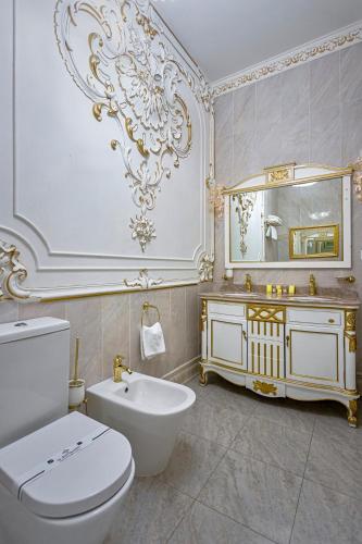 a bathroom with a white toilet and a sink at De Versal in Odesa
