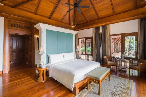 a bedroom with a bed and a table and chairs at JW Marriott Phuket Resort and Spa in Mai Khao Beach