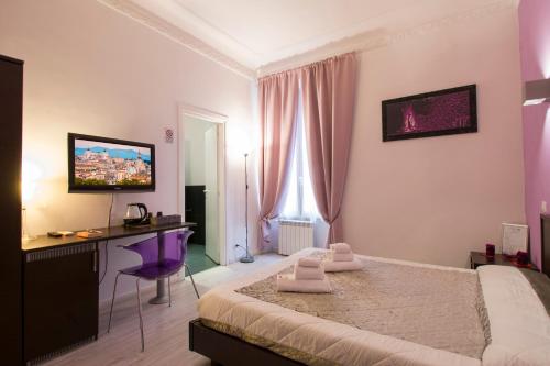 um quarto com uma cama, uma secretária e uma televisão em Chroma Italy - Chroma Tessera em Roma