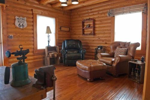 a living room with leather furniture in a log cabin at Shirley's Bed And Breakfast in Roanoke