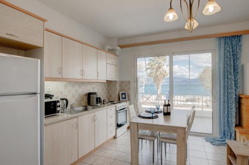 a kitchen with a table and a refrigerator at Seaside Apartments in Áyios Vasílios