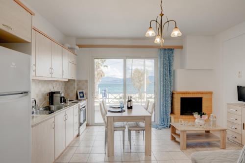 a kitchen with a table and a dining room at Sugar Blue - Apartments on the beach in Áyios Vasílios