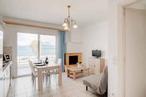 a kitchen and living room with a table and a desk at Seaside Apartments in Áyios Vasílios