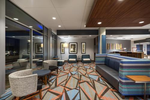 una sala de espera con sillas, un sofá y mesas en Holiday Inn Express & Suites Greenville SE - Simpsonville, an IHG Hotel, en Simpsonville
