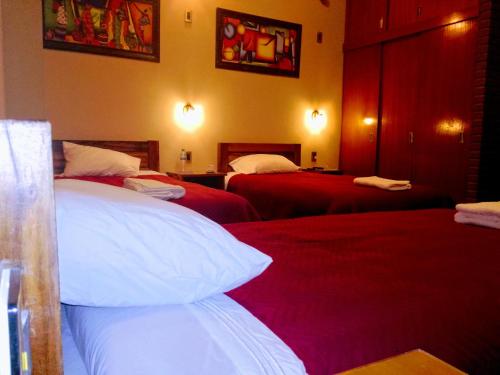 a hotel room with two beds with red sheets at Hostal Cagnapa Restobar in Uyuni