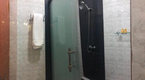 a shower with a glass door in a bathroom at Hostal Cagnapa Restobar in Uyuni