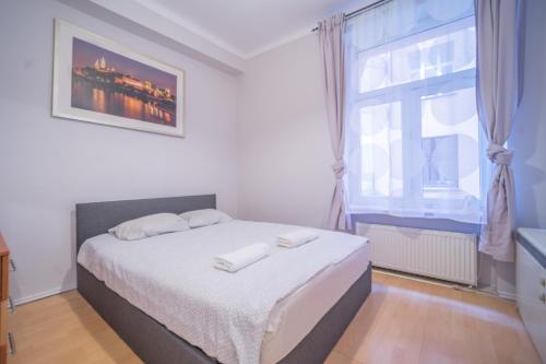 sypialnia z łóżkiem i oknem w obiekcie Apartament Izaaka w Krakowie