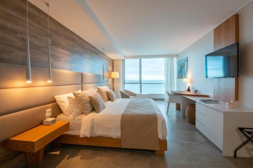 a bedroom with a bed and a desk and a television at Oro Verde Manta in Manta