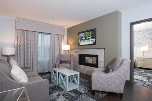 a living room with two chairs and a fireplace at Best Western PLUS Franklin Square Inn in Troy