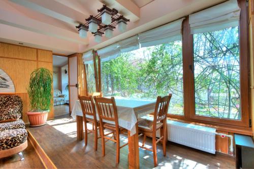 jadalnia ze stołem i krzesłami oraz dużym oknem w obiekcie Маугли - дом-сказка у моря w Odessie