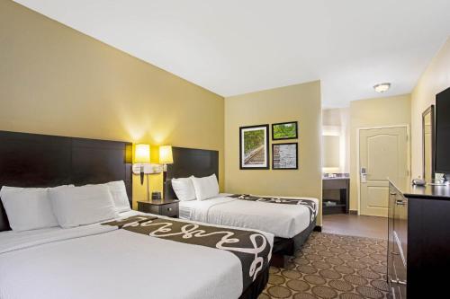 a hotel room with two beds and a desk at La Quinta by Wyndham Lexington South / Hamburg in Lexington