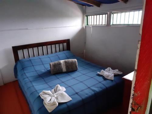 Un dormitorio con una cama azul con arcos. en Atardecer De Salento, en Salento