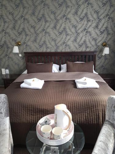 a bedroom with a bed and a table with cups on it at Hotel Amadeus in České Budějovice