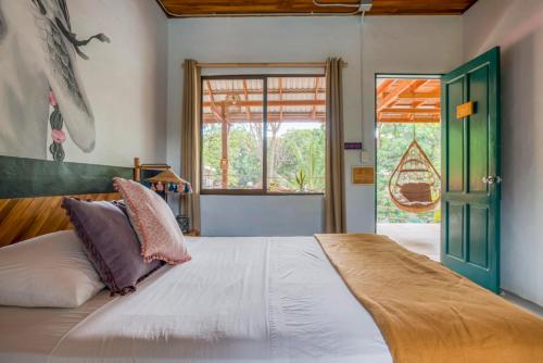a bedroom with a large bed and a window at Selina Santa Teresa South in Santa Teresa Beach