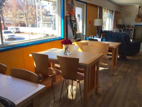 uma sala de jantar com mesas e cadeiras e uma janela em Kelowna International Hostel em Kelowna