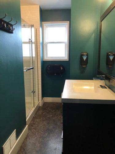 a bathroom with a sink and a shower at Kelowna International Hostel in Kelowna