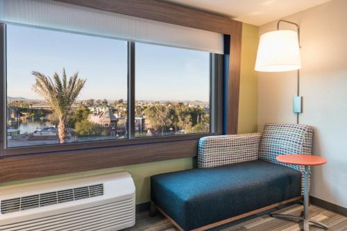 a room with a chair and a large window at Holiday Inn Express & Suites Lake Havasu - London Bridge by IHG in Lake Havasu City
