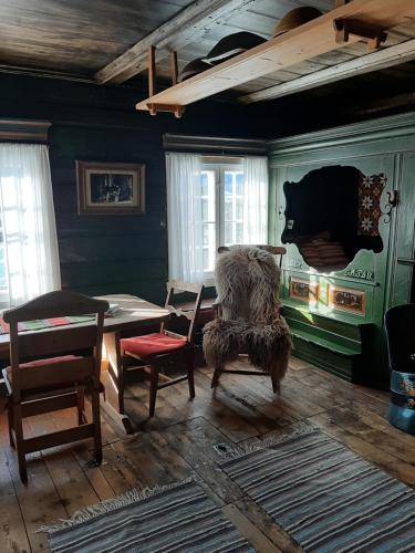 a dining room with a table and a chair at Gamlestugu Greivjord Fjellgard in Tuddal