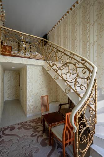 a spiral staircase with a chair and a table at De Versal in Odesa