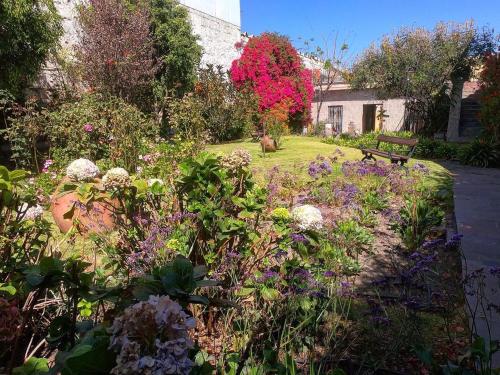 a garden with flowers and a bench in a yard at La Casa de Melgar in Arequipa