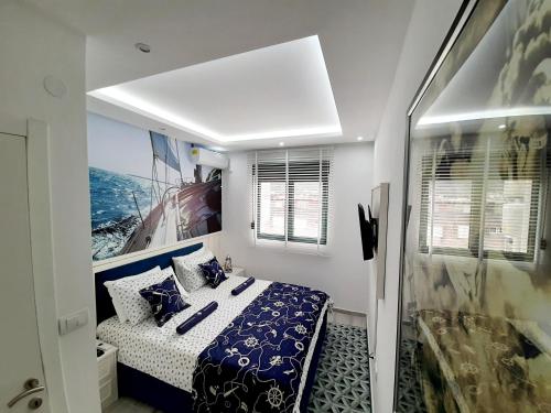 a bedroom with a bed with blue and white sheets at Maritimo di Cattaro****Lux Apartment with Garage in Kotor