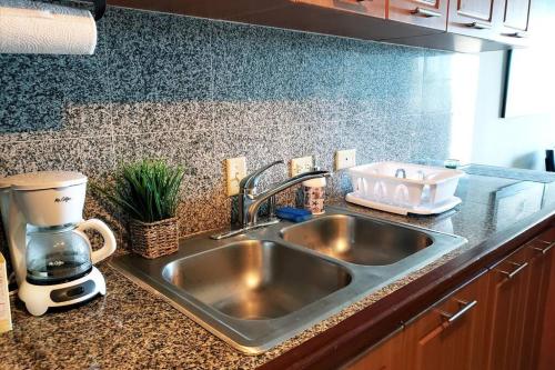 a kitchen sink with a coffee maker on the counter at Wave View Village - Beach Front - Luxury Spot in Rincon