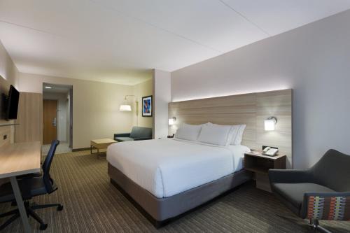 a hotel room with a bed and a desk and chair at Holiday Inn Express & Suites Tavares by IHG in Tavares