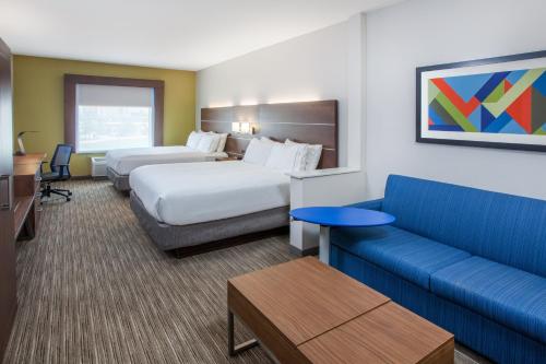 a hotel room with two beds and a couch at Holiday Inn Express & Suites Texarkana by IHG in Texarkana