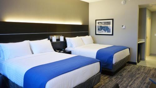 a hotel room with two beds with blue and white sheets at Holiday Inn Express & Suites - Jacksonville W - I295 and I10 by IHG in Jacksonville