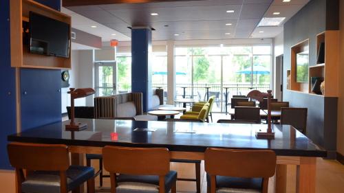 a lobby with a large table and chairs at Holiday Inn Express & Suites - Jacksonville W - I295 and I10 by IHG in Jacksonville