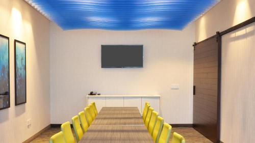 a conference room with a table and yellow chairs at Holiday Inn Express & Suites - Jacksonville W - I295 and I10 by IHG in Jacksonville