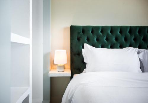 a bed with a green headboard and a lamp at BnB MEDINA in Marrakech