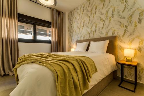 a bedroom with a bed with a green blanket on it at Calpe Beach & City - Premium in Calpe