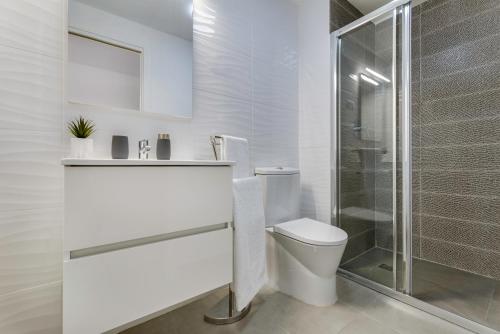 a white bathroom with a toilet and a shower at Calpe Beach & City - Premium in Calpe