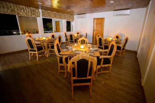 a dining room with tables and chairs with candles at PERLA Dhangethi in Dhangethi