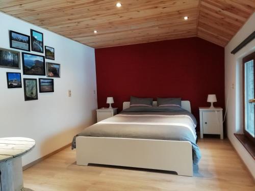 a bedroom with a large bed and a red wall at Entre Nature Et Circuit in Francorchamps