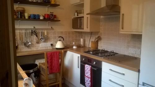 uma cozinha com armários brancos e um forno com placa de fogão em Waverley em York