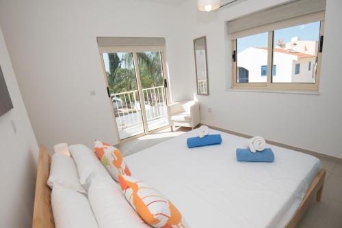 a white bedroom with a bed and a couch at Villa Pomelo in Protaras