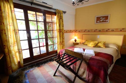 sypialnia z łóżkiem i dużym oknem w obiekcie Hosteria Amparo w mieście Neuquén