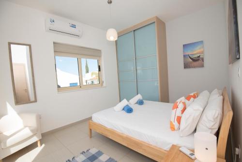 a bedroom with a bed and a couch and a window at Villa Pomelo in Protaras