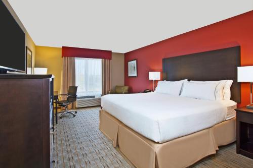 a hotel room with a large bed and a television at Holiday Inn Express & Suites Springfield by IHG in Springfield