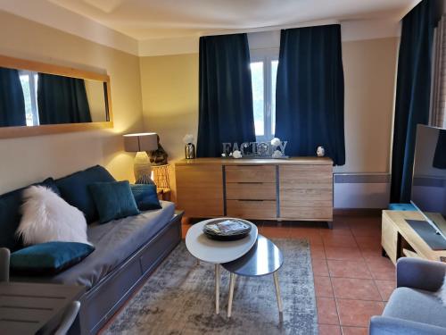 un salon avec un canapé et une table dans l'établissement Appartement piscine mer montagne, aux Issambres