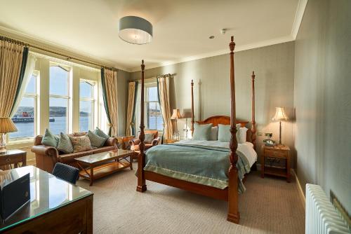 a bedroom with a bed and a living room with a couch at Oban Bay Hotel in Oban